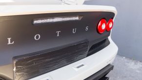 Lotus logo on the back of a white car with a black backend.