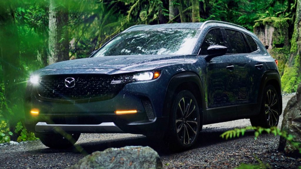 The Mazda CX-50 is driving in nature.