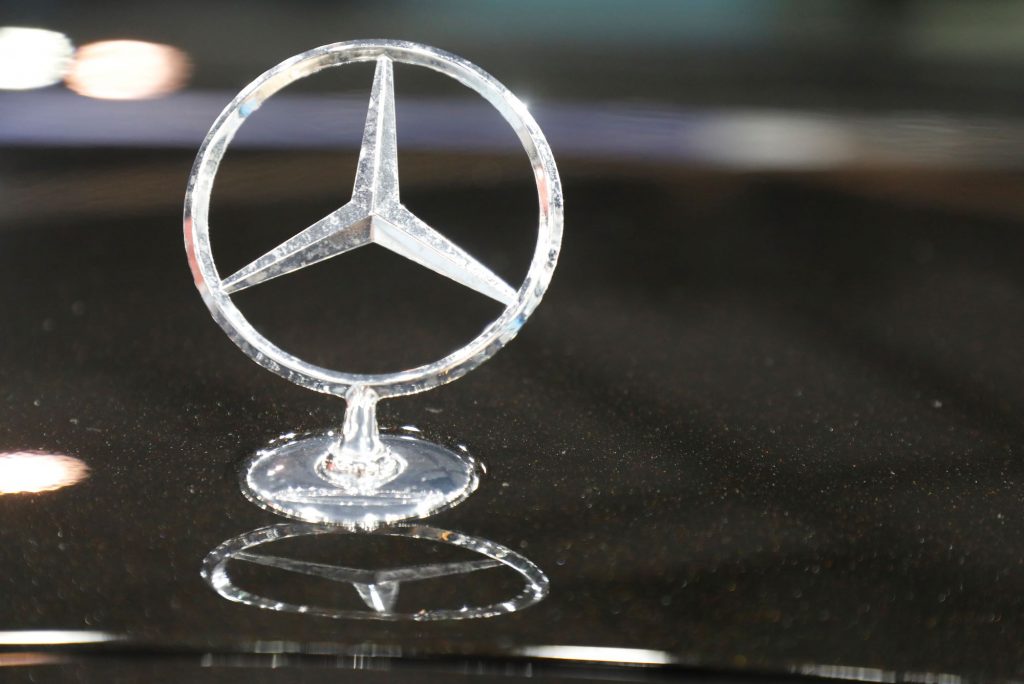 A chrome Mercedes-Benz logo on top of a black vehicle.
