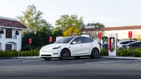 A white Tesla Model Y at a Tesla Supercharger