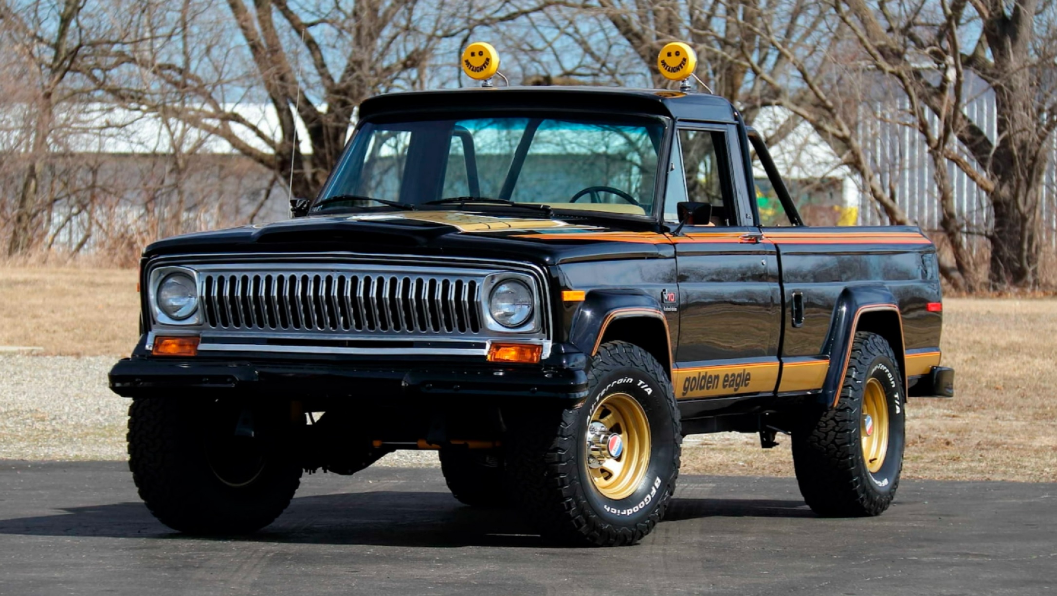 A black-and-gold modified 1978 Jeep J10 Golden Eagle in a parking lot