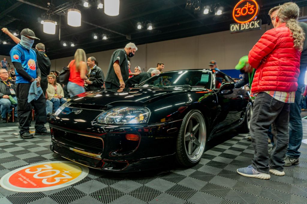 The front view of a black Modified 1994 Toyota Supra Mk4 Turbo in line at the 2021 Mecum Chicago auction surrounded by people