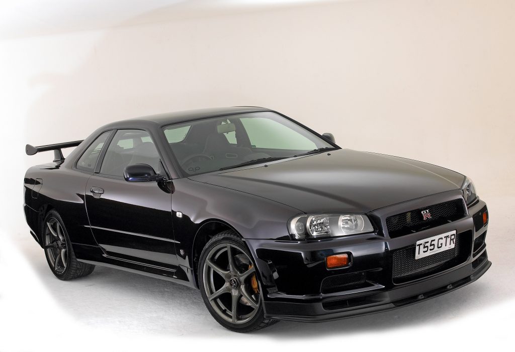 The Nissan R34 GT-R in black shot from the front 3/4