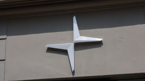A silver Polestar logo on the side of a tan building.