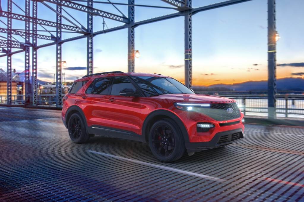 Red 2022 Ford Explorer driving over a bridge, it's one of the best commuter SUVs, according to KBB.