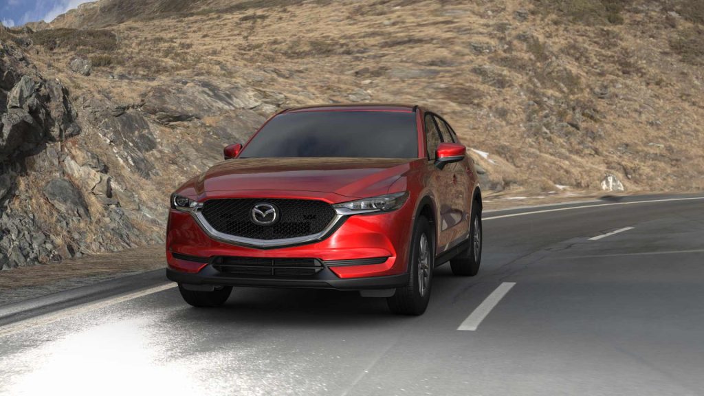 Red 2022 Mazda CX-5 crossover SUV driving on a curvy road