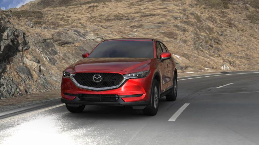 Red 2022 Mazda CX-5 driving on a curvy road