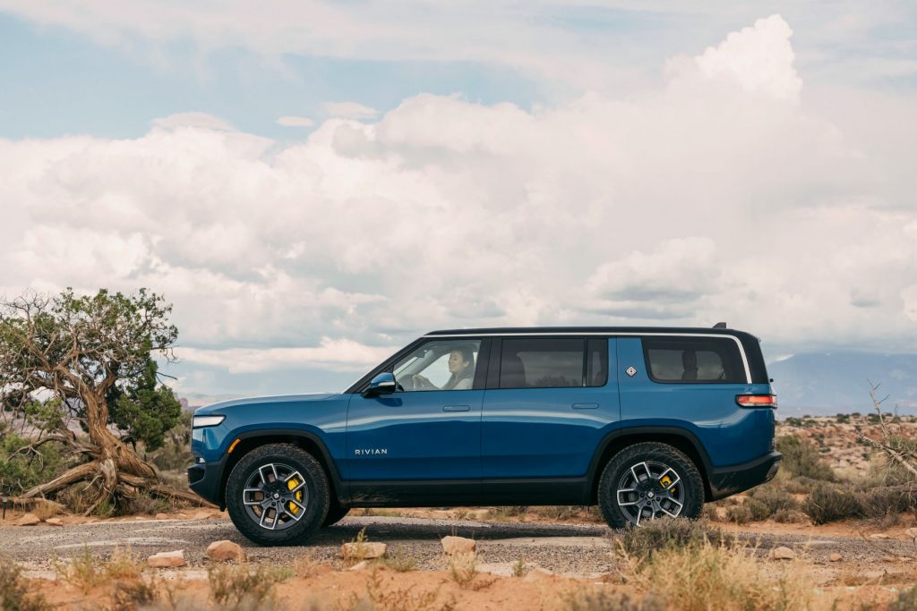 Rivian Blue 2022 Rivian R1S EV SUV driving off-road in the desert, the Rivian electric vehicle plant will cost $5 billion