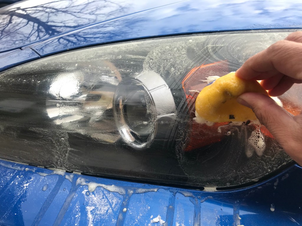 Cleaning the S2000's headlight with a lemon dipped in baking soda.