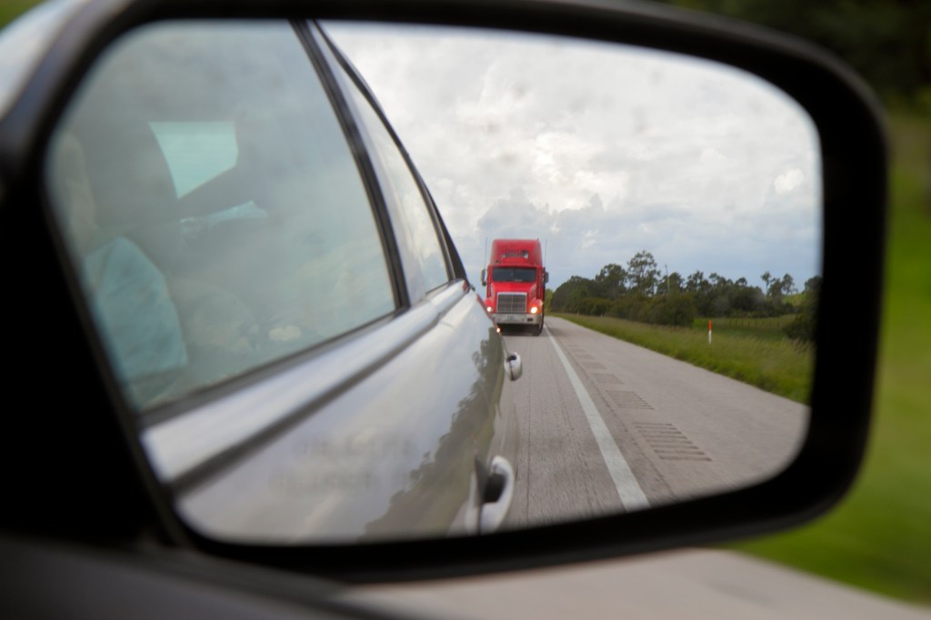Semi-truck in rear view mirror
