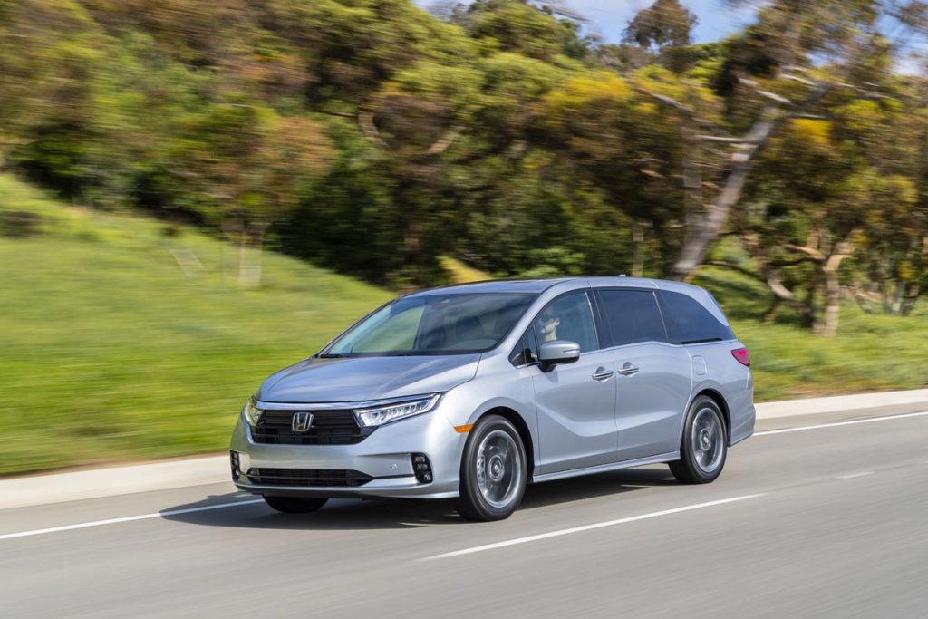 Silver 2022 Honda Odyssey, save money on gas, driving by a forest