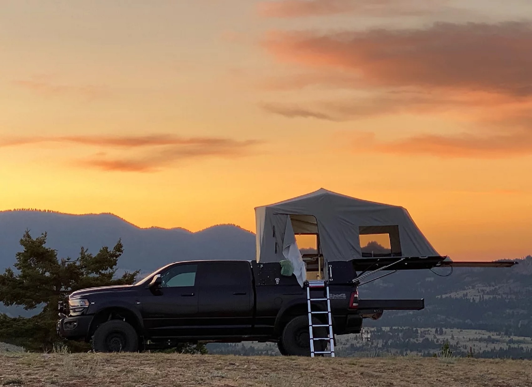 The side view of a Skinny Guy Camper mounted on a black Ram 2500 in the desert
