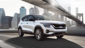 Snow White Pearl 2022 Kia Seltos driving under a bridge