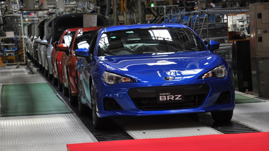 Blue Subaru BRZ coming off a factory assembly line. Subaru recently announced that it expects profits to drop by nearly half due to the global chip shortage