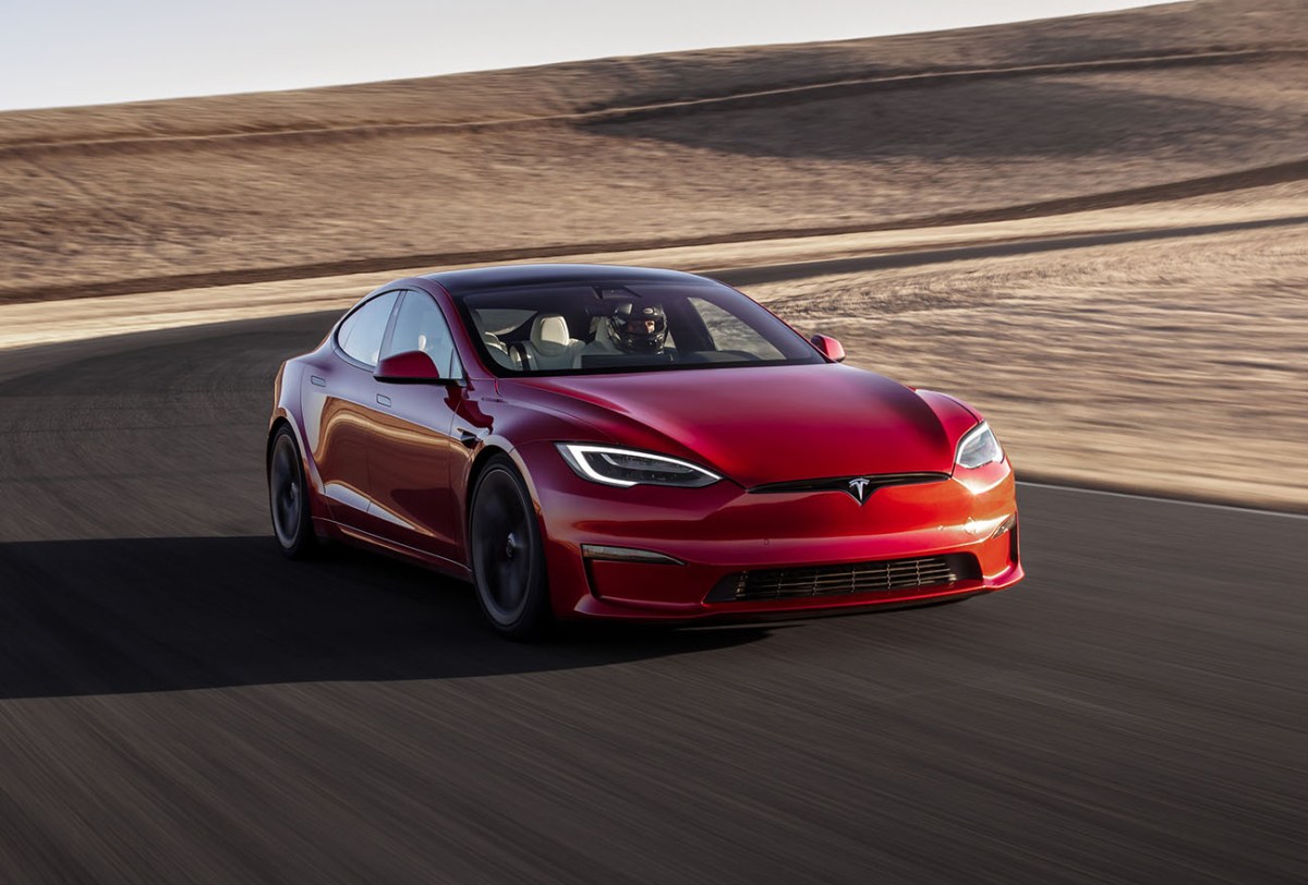A red Tesla Model S driving on a race track toward the camera