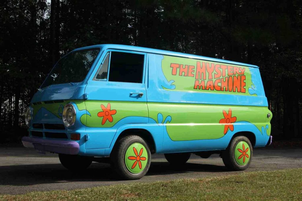 The Mystery Machine cartoon car from Scooby-Doo parked next to a forest