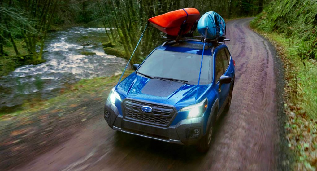 A blue 2022 Subaru Forester Wilderness is driving on a trail. 
