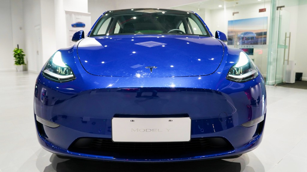 A blue Tesla Model Y is on display.