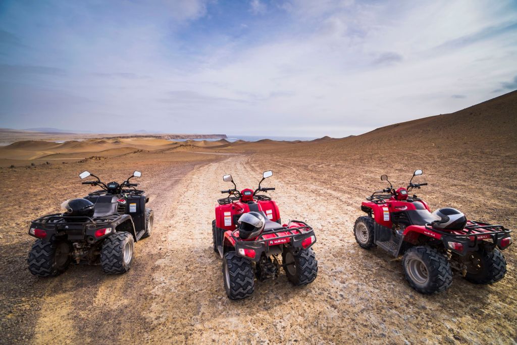Three used ATVs parked in the desert. 