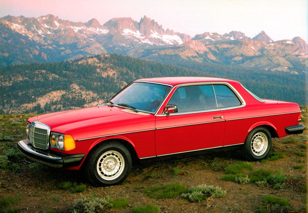 A red W123 Mercedes 300CD Turbodiesel coupe on a mountaintop