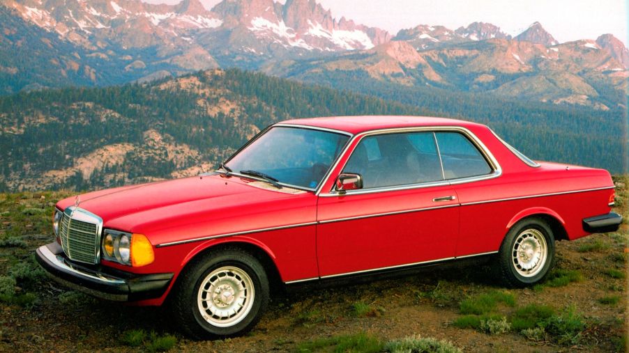 A red W123 Mercedes 300CD Turbodiesel coupe on a mountaintop
