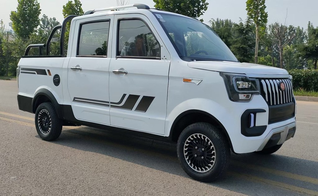 White mini ChangLi electric truck with a F-150 face that's sold on Alibaba in China parked in the middle of a street