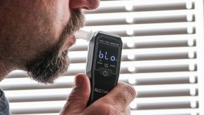 A man uses a breathalyzer device