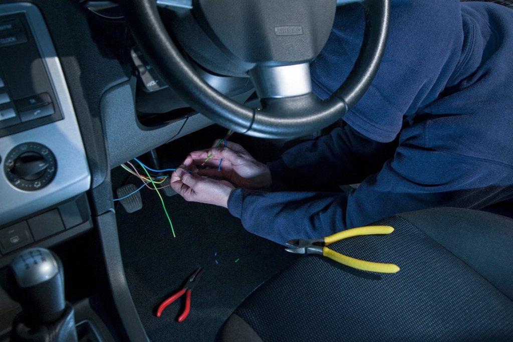 A man doing some wiring on a car.