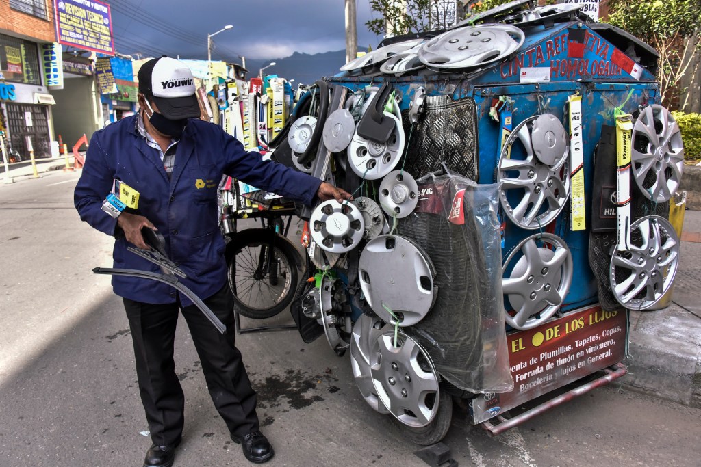 A man sells car parts on a stand.