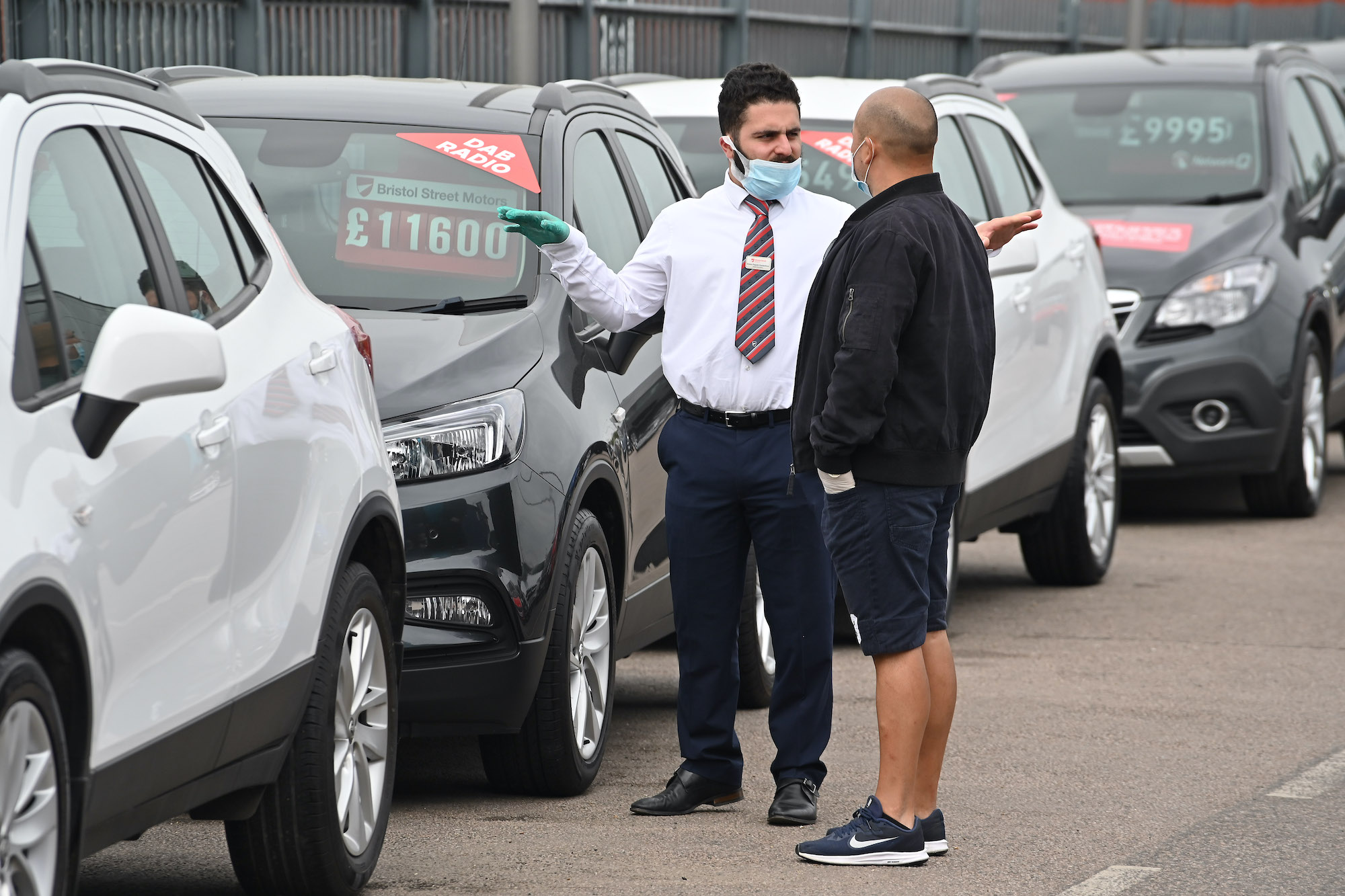 a car salesman talks to a customer on the sales lot, when is the best time of the year to buy an SUV?