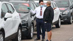a car salesman talks to a customer on the sales lot, when is the best time of the year to buy an SUV?