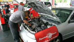 A jiffy lube mechanic changes the oil on a car