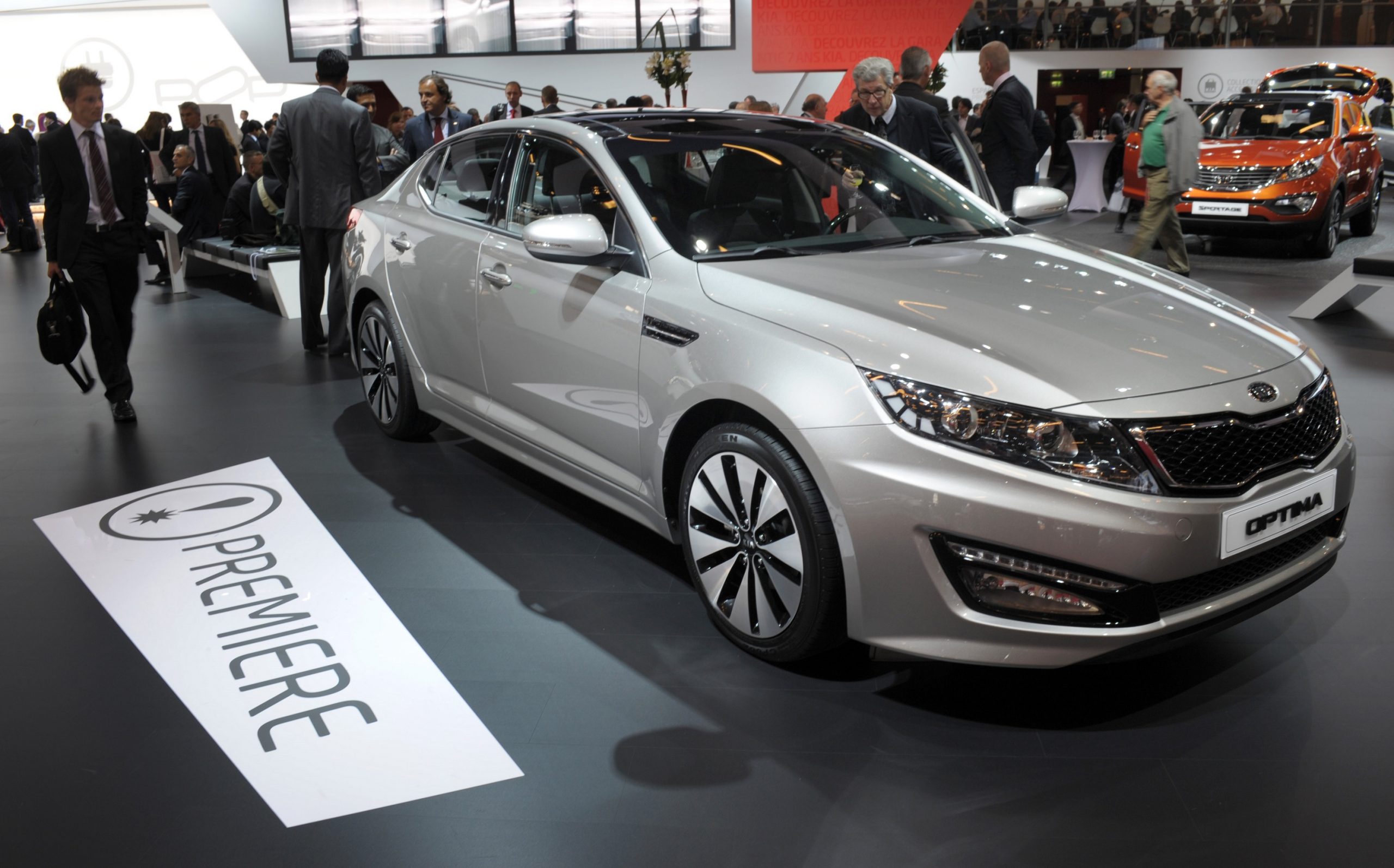 A silver Kia Optima shot from the 3/4 angle at an auto show