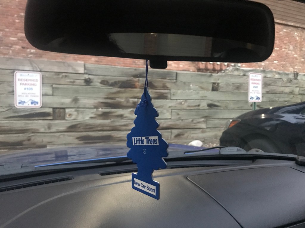 Little Tree car freshener hanging in a rearview mirror