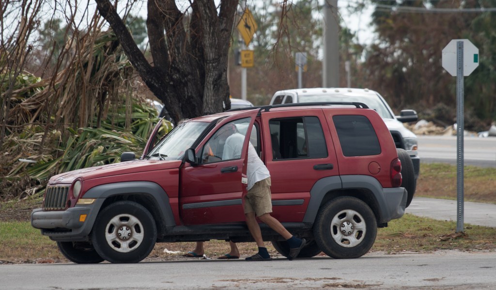 Motorists push a stalled car in a gasoline line in Big Pine Key.
