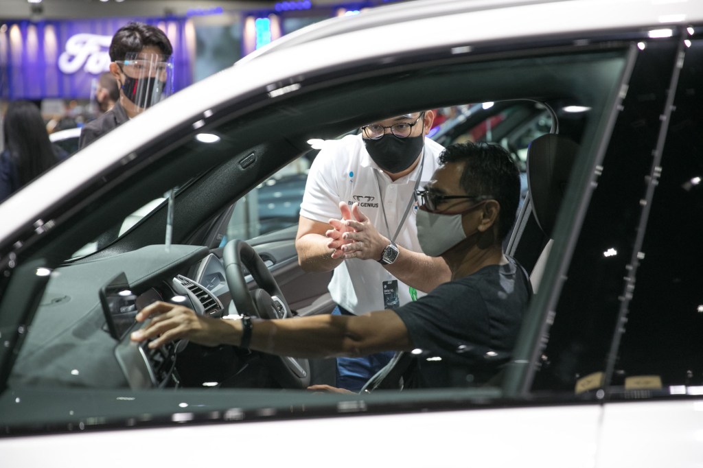 A salesman introduces a BMW car to a guest at the 41st Bangkok International Motor Show in Bangkok, Thailand