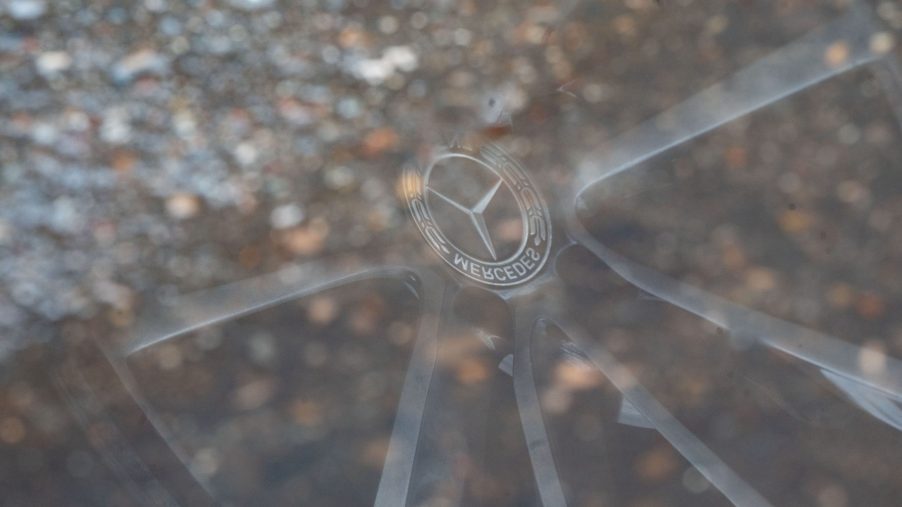 Mercedes Star reflected in a puddle