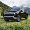 A black 2022 Chevy Silverado parked on grass with a mountainous background