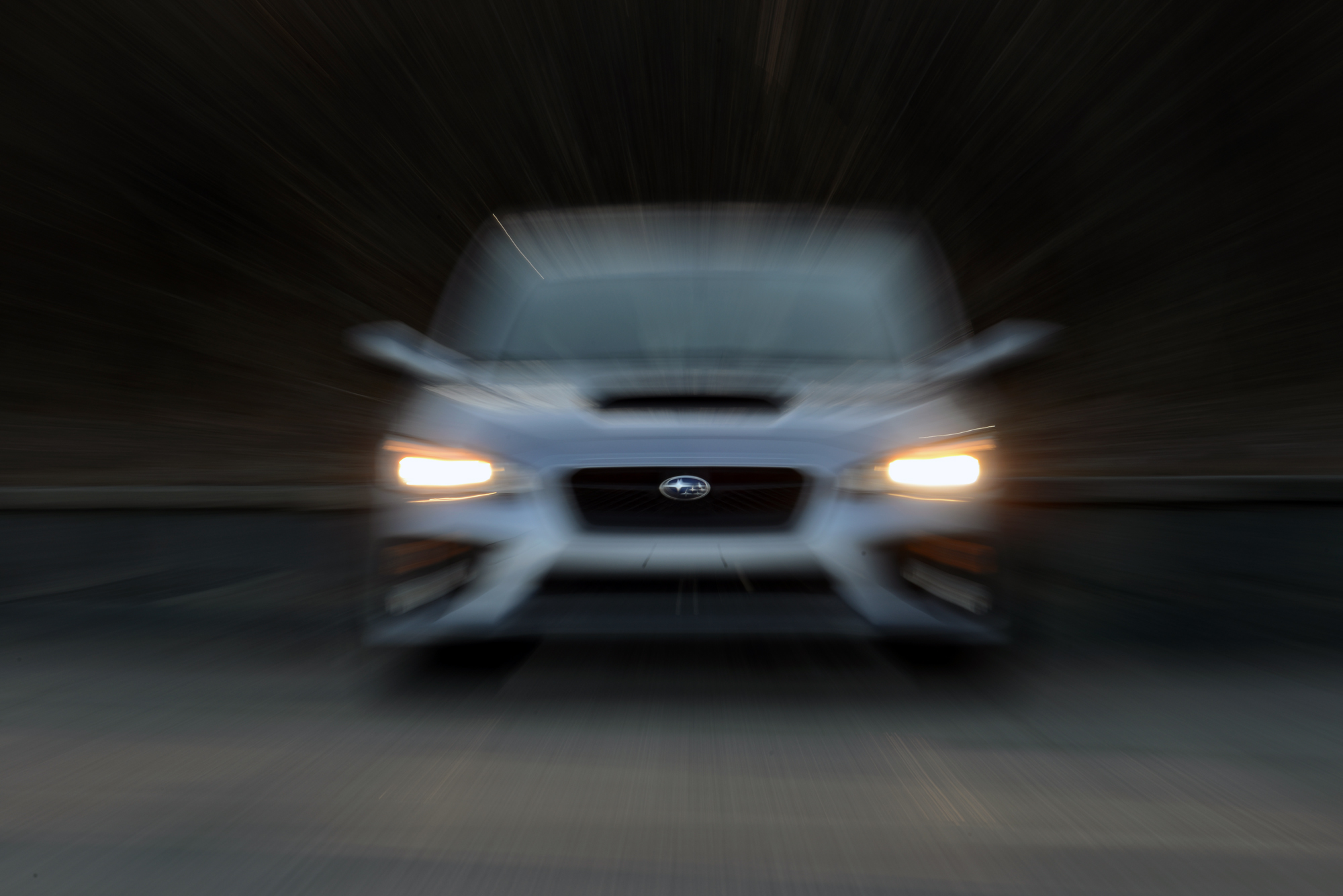 A white WRX shot from the front at night with a blur effect applied to the shot