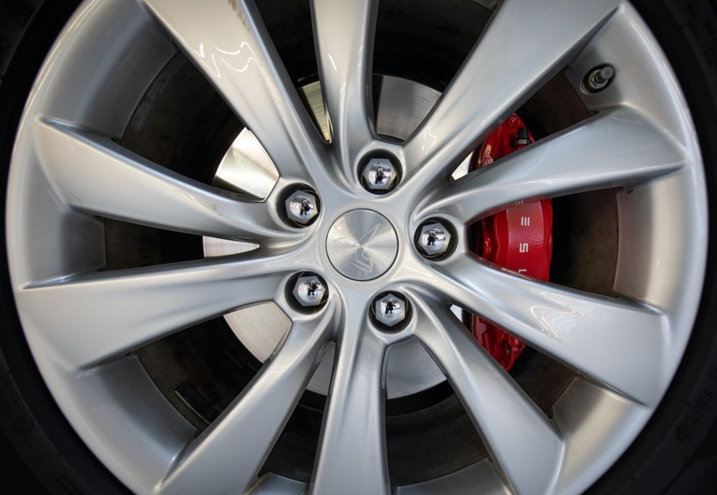 A close-up of the wheel and front brakes on a Tesla