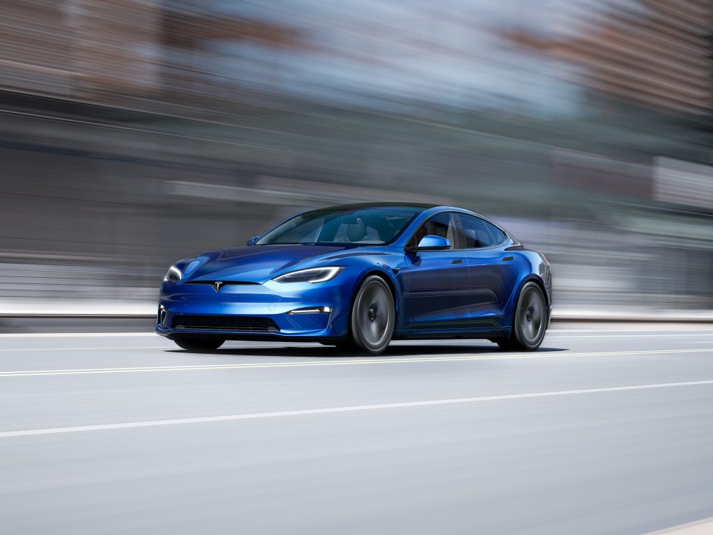 A blue Tesla Model S Plaid EV, shot in motion from the front 3/4