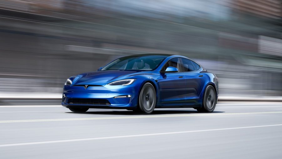 A blue Tesla Model S Plaid EV, shot in motion from the front 3/4