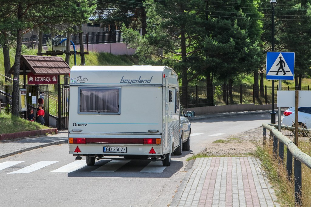 Car towing a caravan is seen in Wdzydze Kiszewskie, Poland.