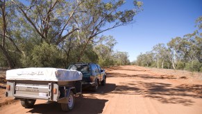 A car with a camper trailer in the desert
