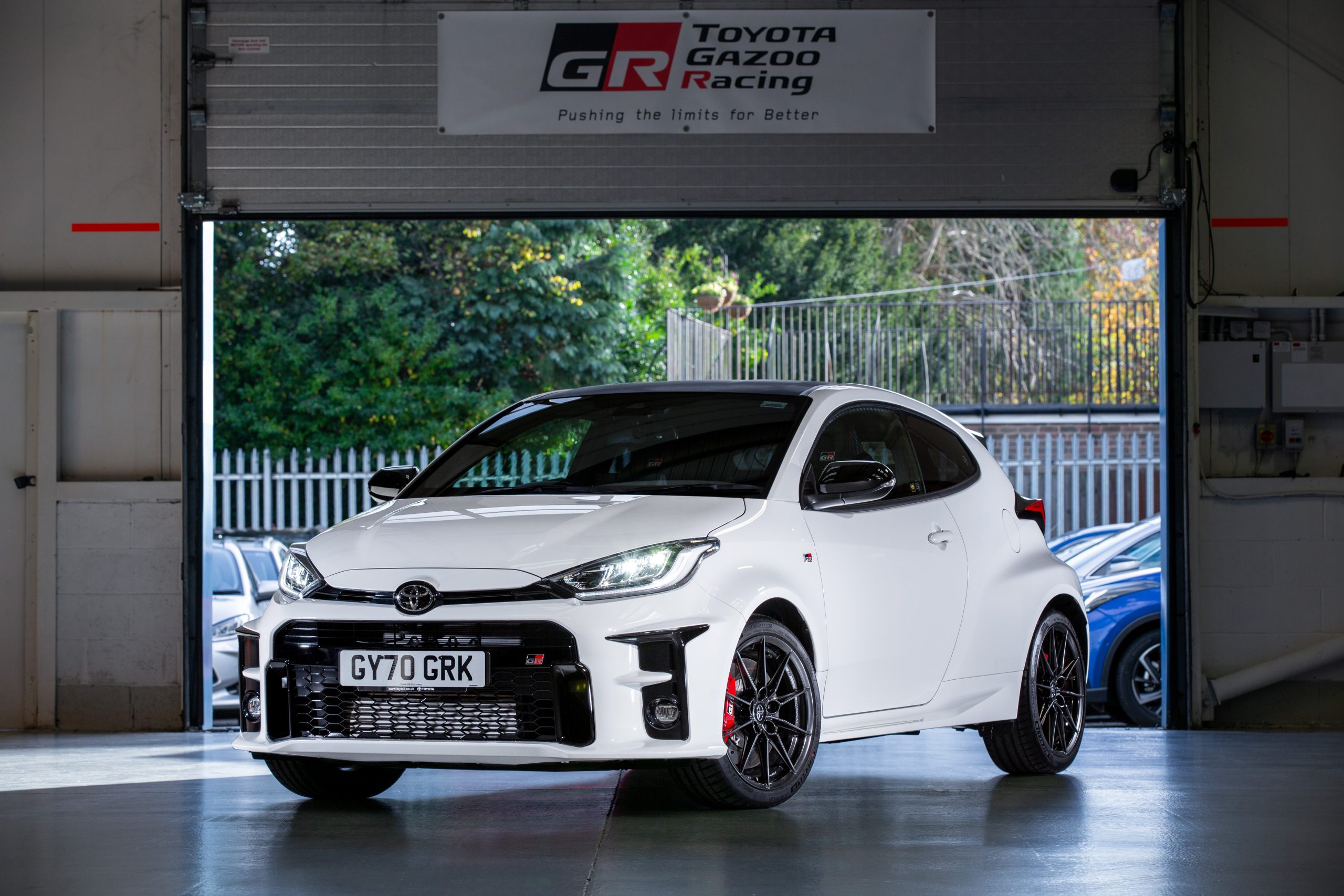 A white Gazoo Racing Toyota Yaris shot from the front 3/4 in a garage