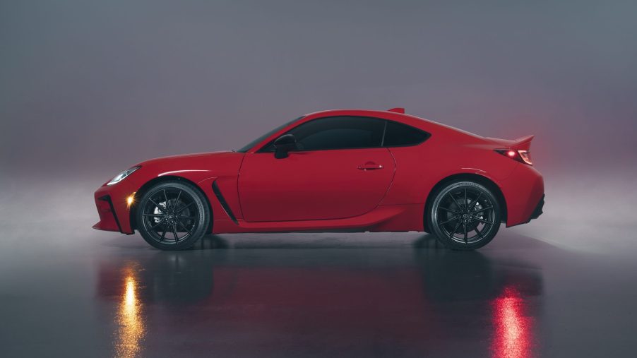 A red Toyota GR86 shot in profile in a photo studio