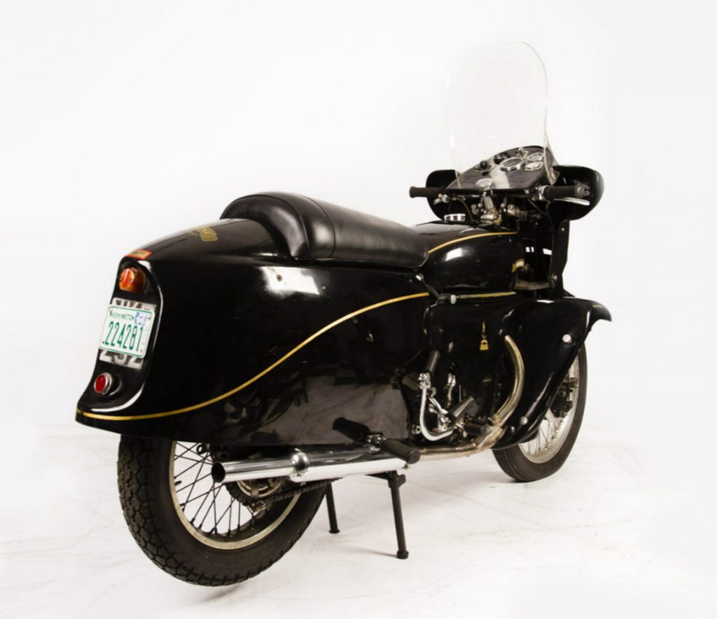 The rear 3/4 view of a lacquer-black 1955 Vincent Black Prince in a white studio