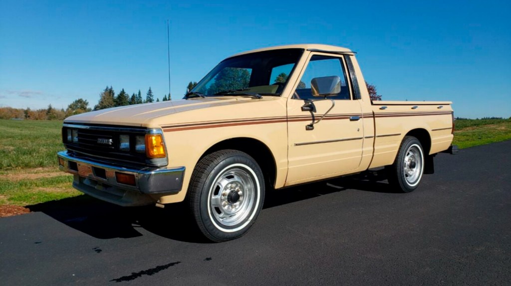 A brown 1983 Nissan 'Datsun 720' pickup truck parked on a road