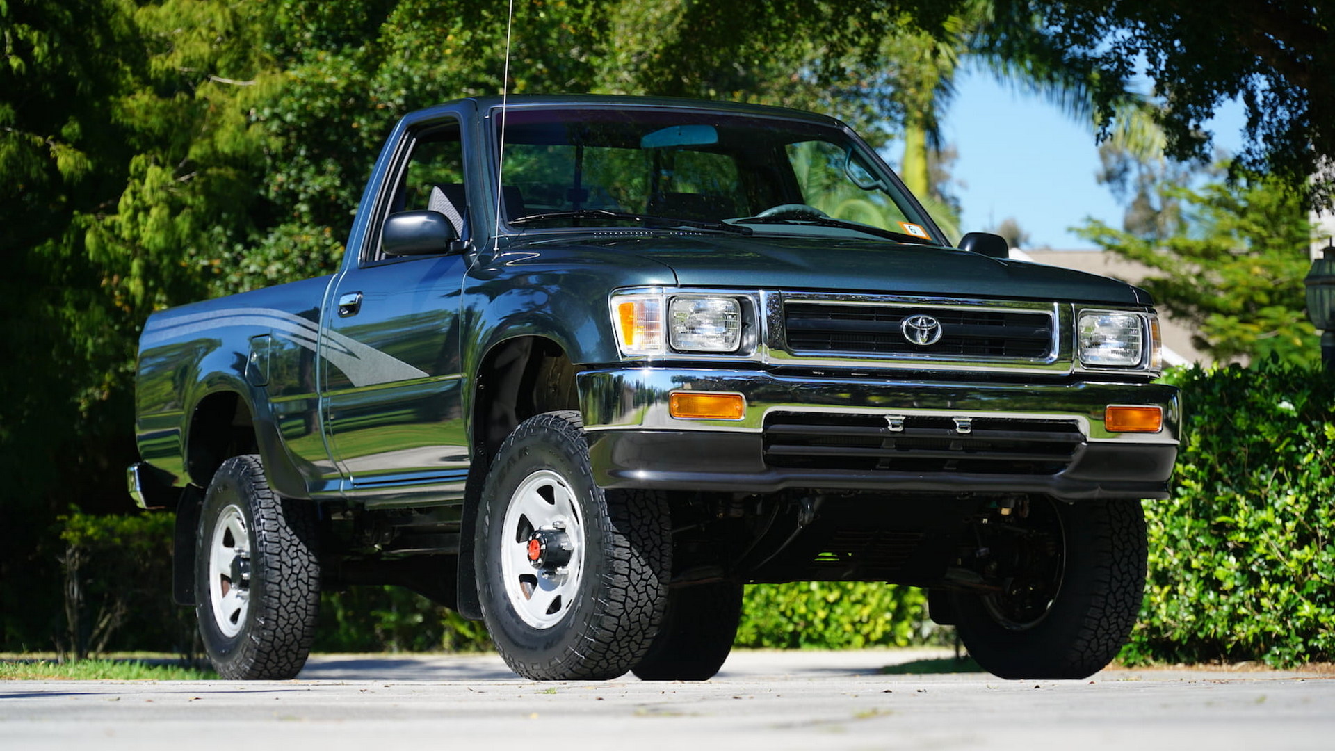 A Forest Green 1993 Toyota Pickup Truck parked outside, it has only 94 miles and could be worth a lot of money.