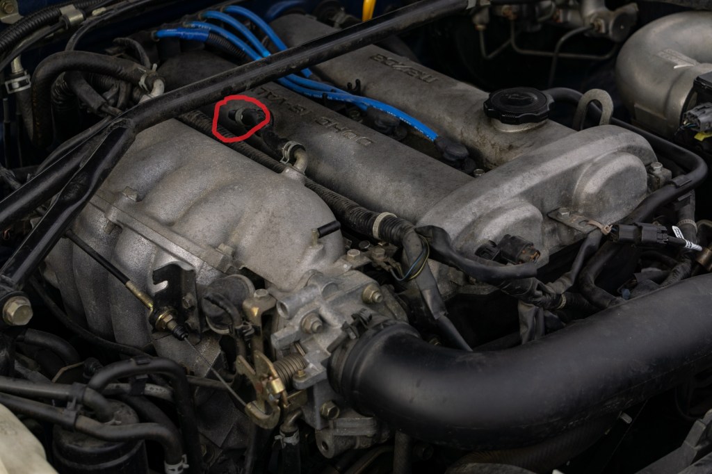 The engine of a 1999 Mazda MX-5 Miata with the PCV valve highlighted in red